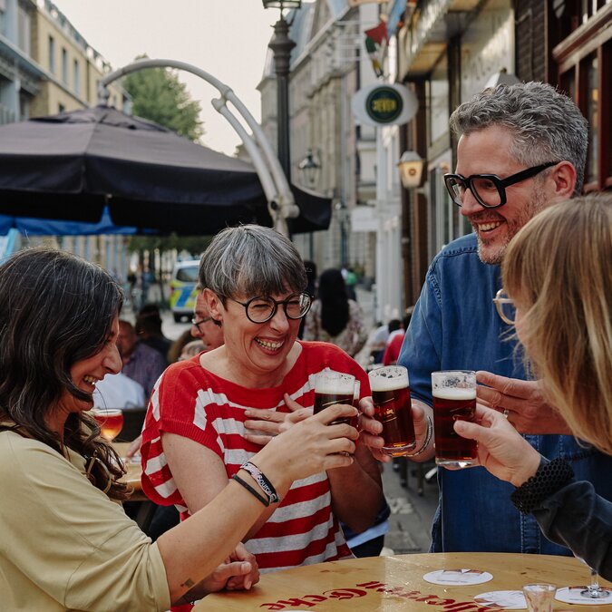 Altstadt  | © Düsseldorf Marketing GmbH, Foto: Sabrina Weniger Menschen in der Düsseldorfer Altstadt die mit einem Bier anstossen.  | © Düsseldorf Marketing GmbH, Foto: Sabrina Weniger