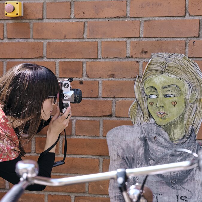 Urban Art Ride | © Düsseldorf Marketing GmbH, Foto: Markus Luigs Person macht ein Foto einers Murals, im Vordergrund ein Velo.  | © Düsseldorf Marketing GmbH, Foto: Markus Luigs