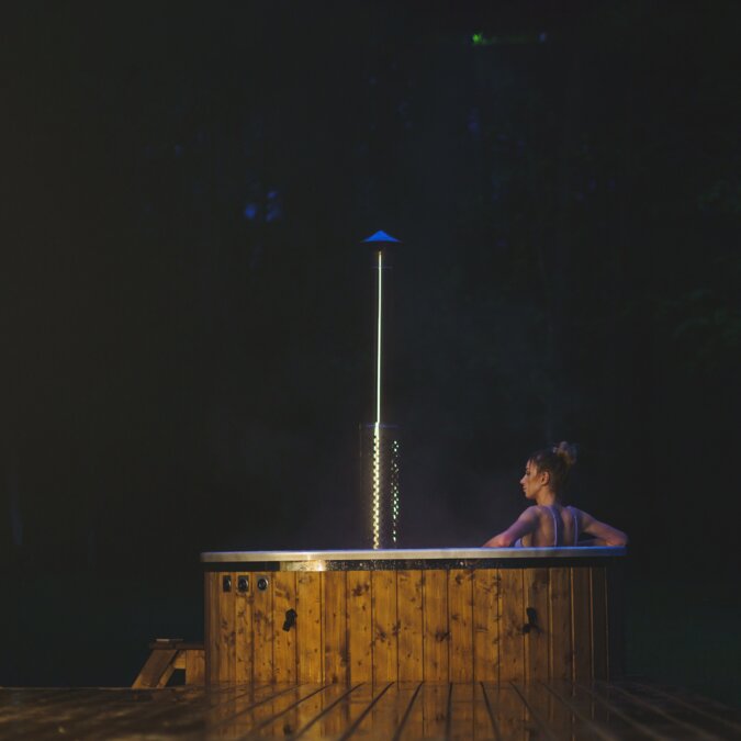 CopenHot | © Shutterstock 2306476535 Junge Frauen kühlen nachts in der Natur in heißem Wanne SPA. | © Shutterstock 2306476535