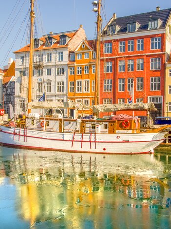 Kopenhagen | © Shutterstock 2422860833 Farbige Häuser und weiße Vintage Segelboot in Nyhavn, Kopenhagen die meisten symbolträchtigen Anblick für Reisende. Stadt mit sehr geringem Verkehr, umweltfreundlichem und nachhaltigsten Reiseziel der Welt. | © Shutterstock 2422860833