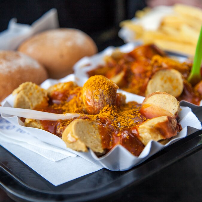 Currywurst | © Shutterstock 1133496686 Deutsche Currywurst mit Currysauce, Pommes Frites und Mayonnaise auf Lebensmittelmarke | © Shutterstock 1133496686