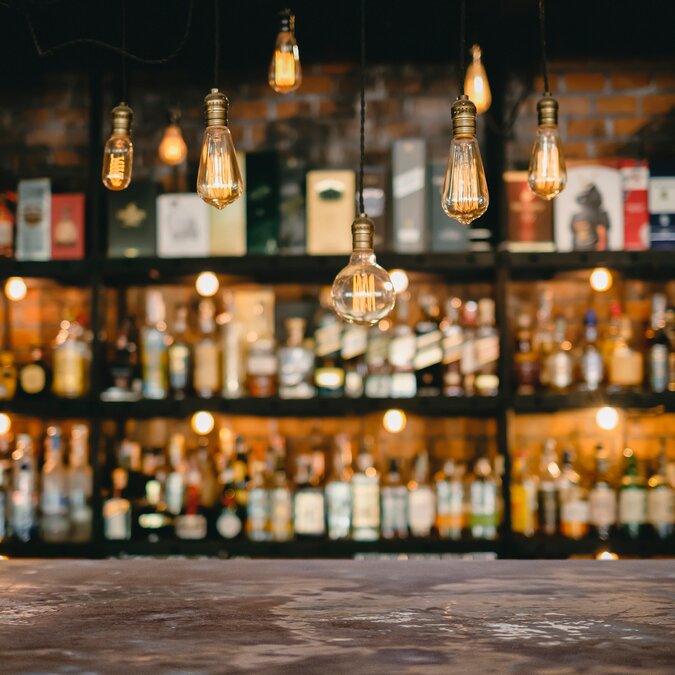 Bar in Berlin | © Shutterstock 1671936808 Metalltisch- und Vintage-Lampen mit Likörbarhintergrund | © Shutterstock 1671936808