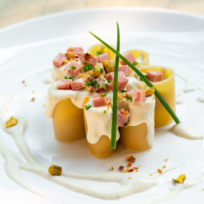 Osteria Bottega | © Shutterstock 1445388362 Paccheri Italienische frische traditionelle Pasta mit Mortadella Bologna Schinken, Käse, Sahne, Pistazien, schöne Garnierung Kunst plating professionellen Küchenchef feines Essen in natürlichem Gegenlicht, Essen im Freien | © Shutterstock 1445388362