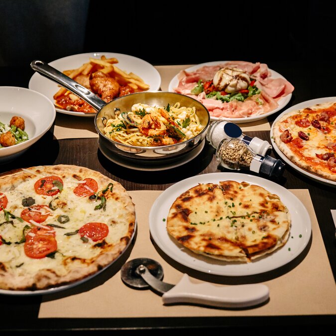 Gastronomie Rom | © Shutterstock 1389645959 Warm servierte italienische Gerichte: Pizza Carbonara und Carpres mit Pizzaschneider, Aufschnitt mit Burrata-Käse, Puccia mit schwarzem Trüffel und Linguini mit Meeresfrüchten. | © Shutterstock 1389645959